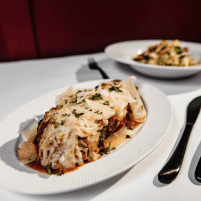 A plate of lasagna and a fork on a table, perfect for indulging in delectable recipes.