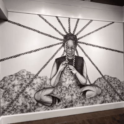 A black and white art piece featuring a woman sitting on a chain.