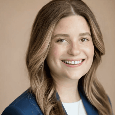 A smiling woman in a blue blazer, dedicated to charter schools.