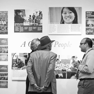 A group of people looking at posters on a wall.