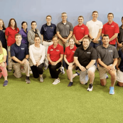 A group of people posing for a photo in a gym.