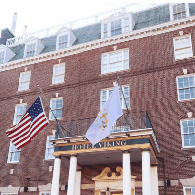 The front of a brick building adorned with two American flags in Newport.