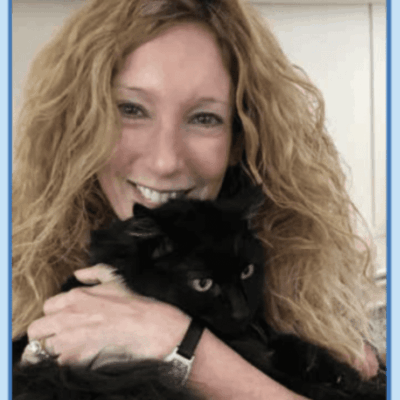 A woman holding a black cat.