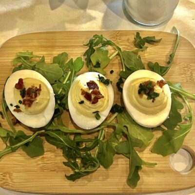 Deviled eggs with bacon and arugula.