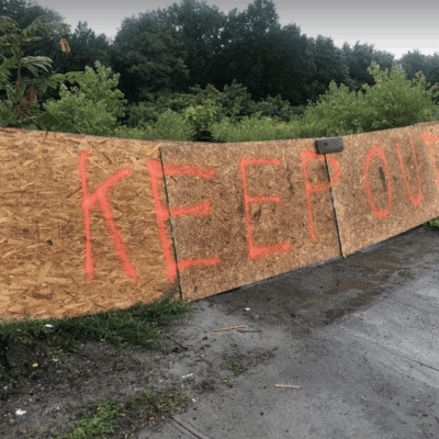 A piece of plywood with the words keep out written on it.