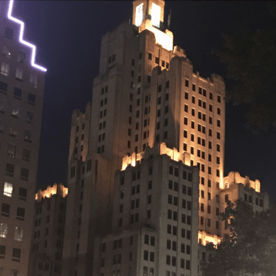 A tall building in Providence lit up at night.