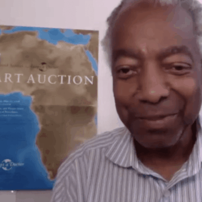 Ray Rickman, a man in a striped shirt, is standing in front of a map.