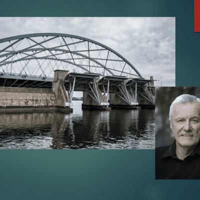 An image of a man standing next to the Providence Hurricane Barrier.