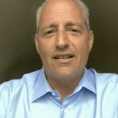 Marc Crisafulli, wearing a blue shirt, is looking at the camera.