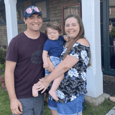 A man, woman, and baby showcasing a delightful family portrait in front of their charming residential abode.