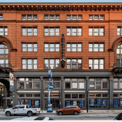 A red brick building with Providence architecture, a car parked in front of it.