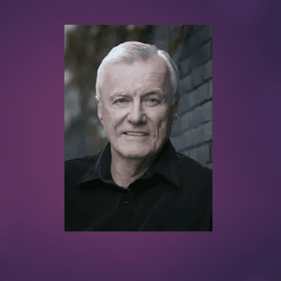 A man in a black shirt with a purple background at the Rhode Island election.