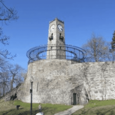 A clock tower sits on top of a stone wall in Central Falls.