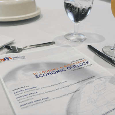 A table is set with a menu and utensils as part of the RI Hospitality Association's event.