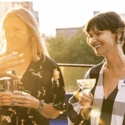 A group of women networking at an event in London, enjoying a glass of wine.