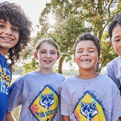 A group of kids in t - shirts taking a selfie.