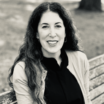 A black and white photo of a woman sitting on a bench, capturing the essence of peacefulness.