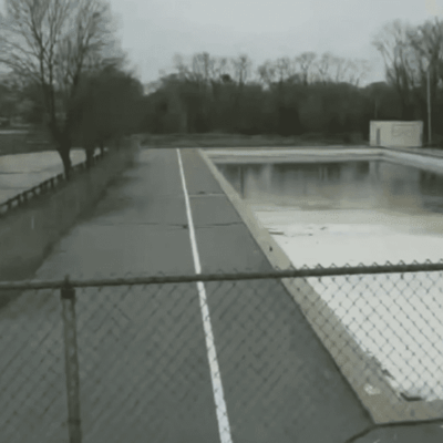 An empty swimming pool with a fence around it in Cranston.
