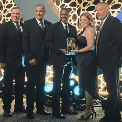 A group of people from Central Falls posing for a photo with an award.