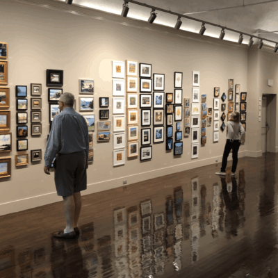 A group of people admiring art in an art gallery.