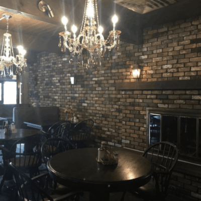 A restaurant featuring a chandelier and a brick wall, offering a charming atmosphere for networking events.