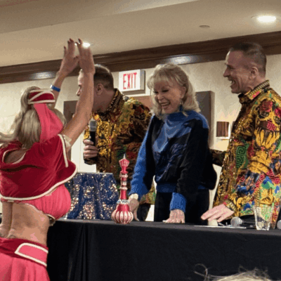 At Ri Comic Con, a woman in a red dress enthusiastically gives a high five to a man.