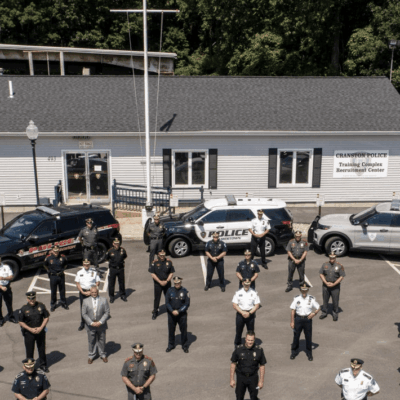 A group of police officers standing in front of a building in Cranston.