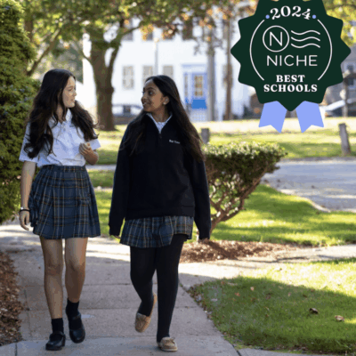 Two girls from Bay View Academy in school uniforms walking down a sidewalk.