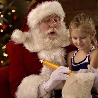 Santa reading a letter to a little girl.
