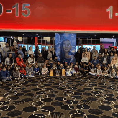 A group of people posing for a photo in a movie theater, capturing "a Wish Come True" moment.