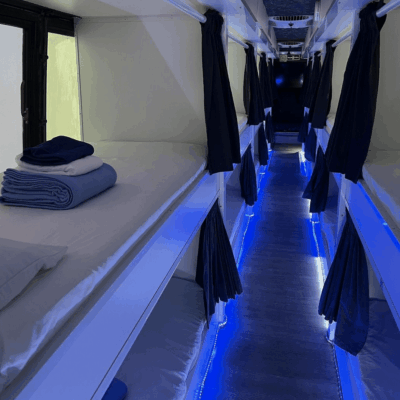 A row of bunk beds in a room with blue lights, providing shelter for homeless individuals in Rhode Island (RI).