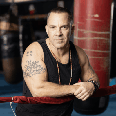 A man leaning against a boxing ring.