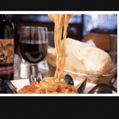 A plate of spaghetti with a glass of wine during Providence Restaurant Week.