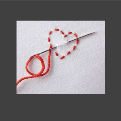 A needle with a red heart on it, symbolizing grief.