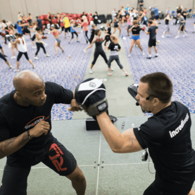 A man in a black shirt is punching a man in a black shirt with Kearns.
