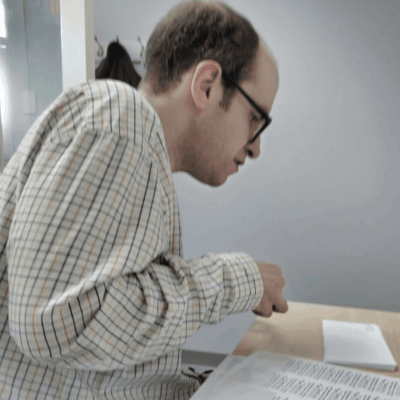 A man with disabilities looking at a piece of paper.