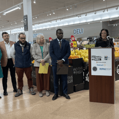 A group of people standing in front of a grocery store accepting SNAP.