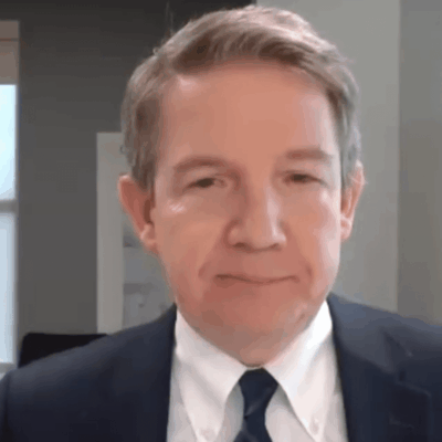 A man in a suit and tie, representing Care New England, is looking at the camera.