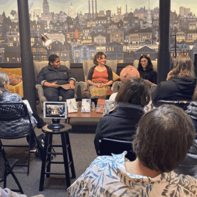 A group of people sitting in chairs, writing in a room.