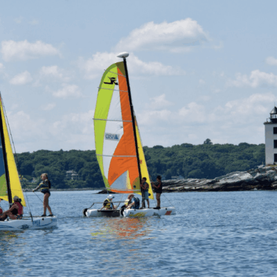 A group of sailing sailboats in the water.