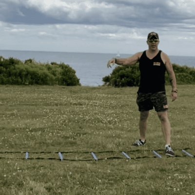 A man standing in a grassy field with a set of poles.