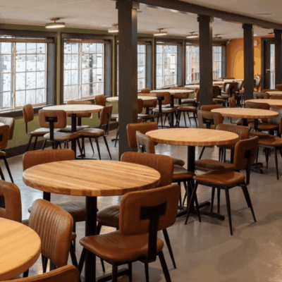 The interior of a restaurant with tables and chairs is designed for networking.