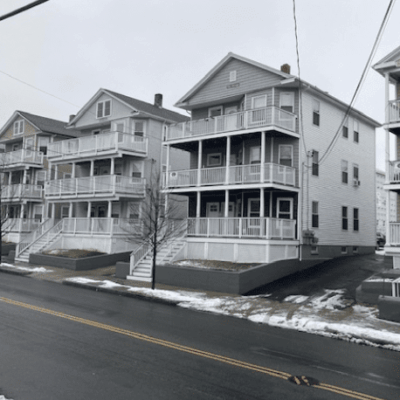 A black and white photo of a row of houses on a snowy street, featured on the endangered properties list.