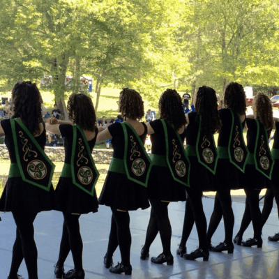 A group of girls performing Irish step dancing on a stage.