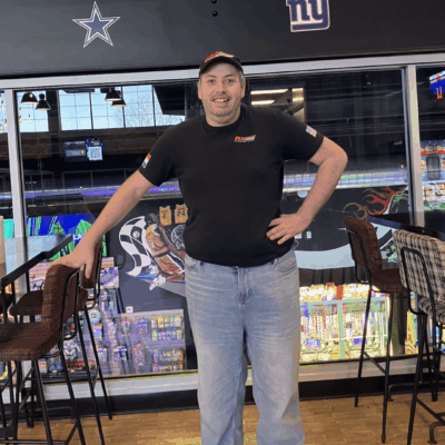 Man in black t-shirt at arcade bar.