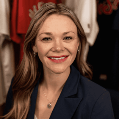 Woman in navy blazer, smiling.