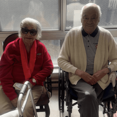 Elderly couple sitting near window.
