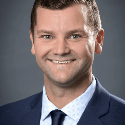 Headshot of smiling man in suit.