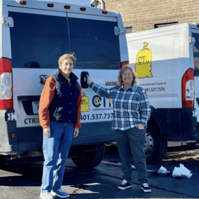 Two women by textile recycling vans.