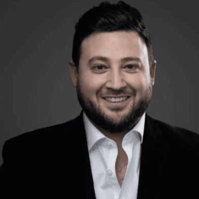 Here's an alt tag for the image: Smiling man in a suit.